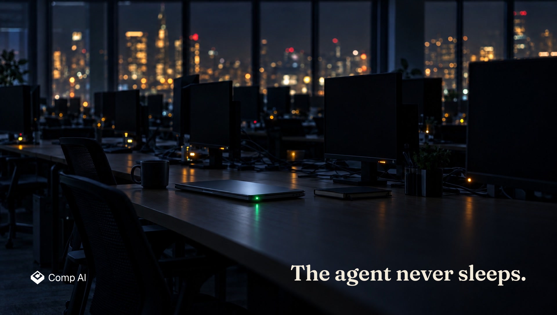 A closed laptop with one green status light in a dark office